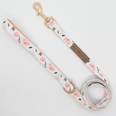 White dog lead with pink roses and white magnolias. and gold hardware